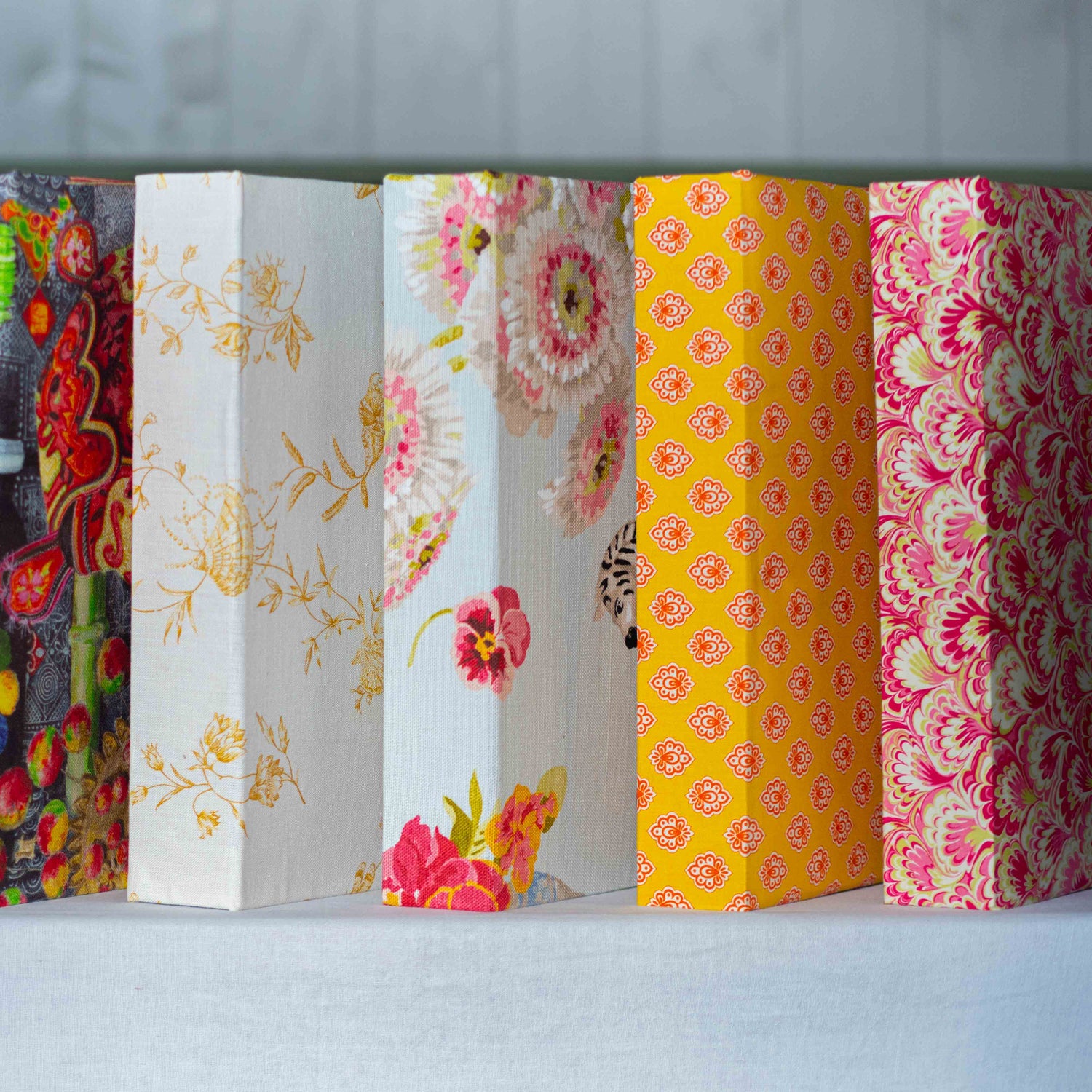 papierundstoffe A4 Letterschachteln und Letterboxen für ihre Briefe mit Quaste oder Gummiband in traumhaftschönen Stoffen von Pierre Frey, Mulberry, Fortuny, Etro handgemacht aus der Papierwerkstatt nebeneinander aufgereiht